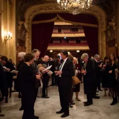 Eleganckie przyjęcie w teatrze. Ludzie rozmawiają, piją wino, zastanawiając się, co to jest antrakt.