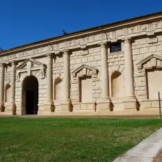 Fasada budynku z kolumnami i łukami, ozdobiona detalami architektonicznymi, odzwierciedla styl manieryzm.