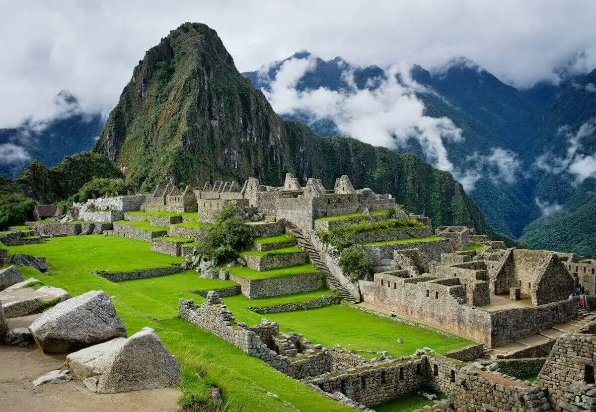Machu Picchu, z jego tarasami i kamiennymi budowlami, to prekursor architektoniczny, górujący nad zielonymi dolinami.