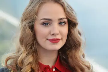 Młoda, uśmiechnięta gosiewska aktorka z burzą blond włosów i czerwoną szminką na ustach.