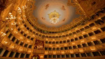 Złocone wnętrze teatru, pełne luksusowych balkonów i żyrandoli, zaprasza na wspaniałą **operetkę**.